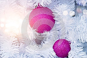 Purple christmas ornament decorating on white christmas tree