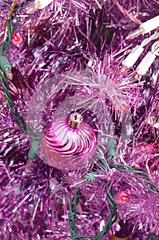 Purple Christmas tree with pink lights and ball ornament