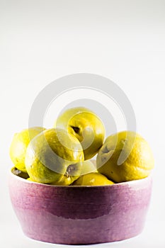 Purple clay bowl filled with fresh quinces