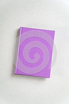 Purple closed notebook on gray top view