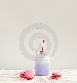 Purple coffee in stylized mason jar cup with macarons and colorful decoration. Blueberry milk shake, cocktaill, frappuccino. Unico photo