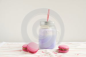Purple coffee in stylized mason jar cup with macarons and colorful decoration. Blueberry milk shake, cocktaill, frappuccino. Unico photo