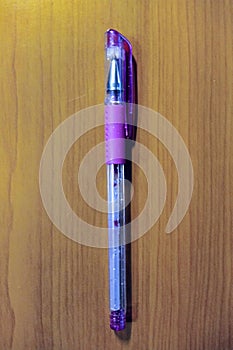 Purple color pen on wooden background