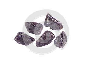 Purple color tumbled Iolite or Cordierite gemstones, isolated on white background, lot of copy space.