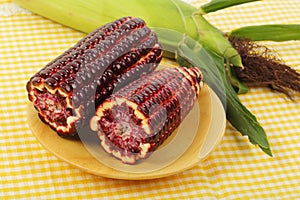 Purple corn fruits on wooden plate