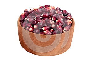 Purple corn seeds in wooden bowl isolated on white background with full depth of field