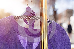 Purple dress hanging on a golden clothes rack