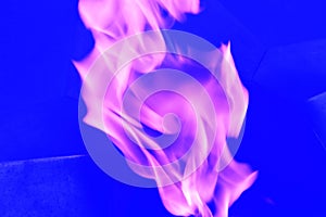Purple flames, abstract swirls of lilac smoke on a blue background