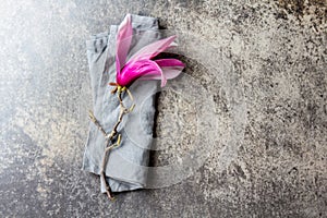 Purple flower of magnolia on stone background. Top view