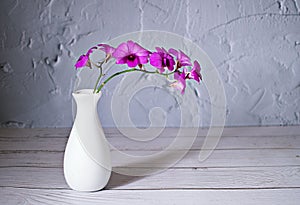 Purple flowers in vase on the table,Purple-pink flower orchids still life background or wallapper cooktown ,Dendrobium bigibbum ma