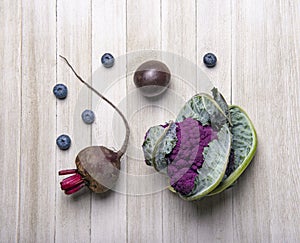 Purple fruits and vegetables over wood background