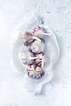 Purple garlic bulbs on rustic white background