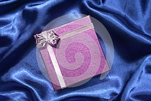 Purple gift box on blue silk