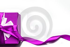 Purple gift box with bow and ribbon on a white background, isolated image