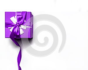 Purple gift box with bow and ribbon on a white background, isolated image