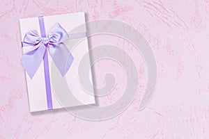 Purple gift box on pink background with copy space for text top