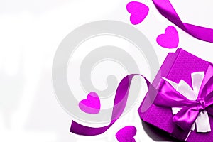 Purple gift box with ribbon and hearts on a white background, isolated image