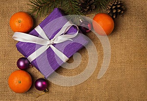 Purple gift with white ribbon and Christmas decorations