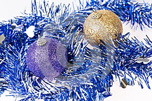 Purple and gold ornaments on tinsel decoration background