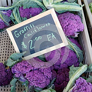 Purple graffiti cauliflower in a bin with chalkboard price