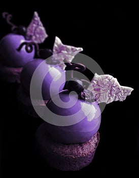 Purple grape dessert with shiny mirror glaze and chocolate decorations