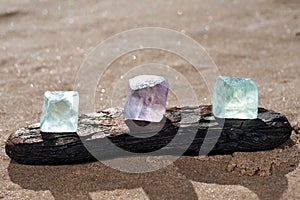 Purple and Green Fluorite Natural Octahedron Crystals on the beach photo
