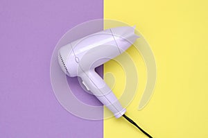 Purple hair dryer on purple and yellow background