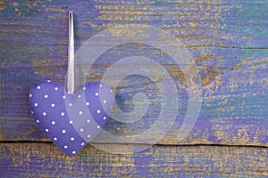 Purple heart shape on purple wooden surface - love and hope, greeting Card.