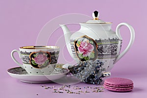 Purple heather with antique porcelain tea cup with saucer and te