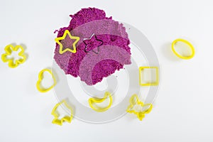 Purple kinetic sand, plastic molds for sand. Top view. White background