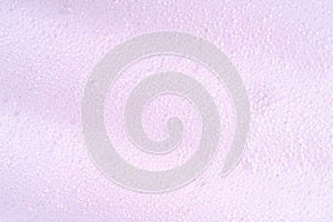 Purple laundry spume. Foam macro background with bubbles. Soapy surface closeup. Foamy cleansing skin care product