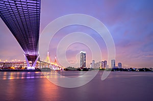 Purple led light under the bridge over the river On a cloudy day in the sky. Bhumibol Bridge, Samut Prakan, Thailand