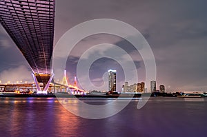 Purple led light under the bridge over the river On a cloudy day in the sky. Bhumibol Bridge, Samut Prakan, Thailand