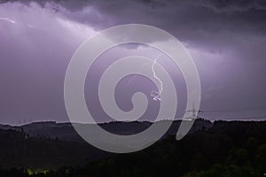 a purple lightning bolt hitting a power line across the field