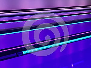 Purple lit bowling lanes with aqua and pink gutter lights