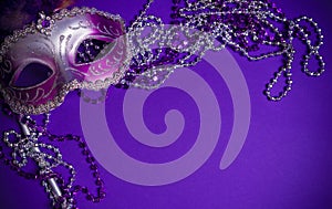 Purple Mardi-Gras or Venetian mask on purple background