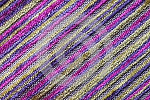 Purple multicolor background of a knitted textile material. Fabric with a striped texture closeup.
