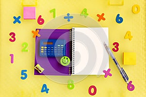 Purple notebook with blank sheet surrounded by numbers and a calculator to learn mathematics