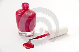 Purple opened nail varnish with spilled on a white background