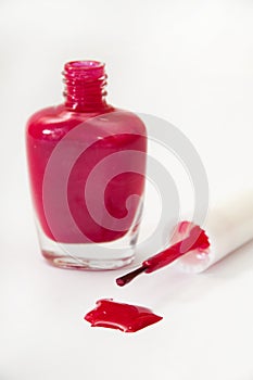 Purple opened nail varnish with spilled on a white background