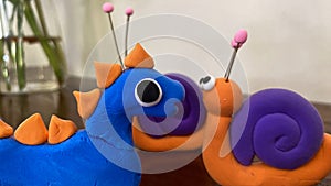 purple and orange clay snails with eyes and antennae photo