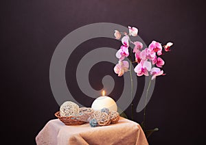 Purple orchid, candle and decorative balls near