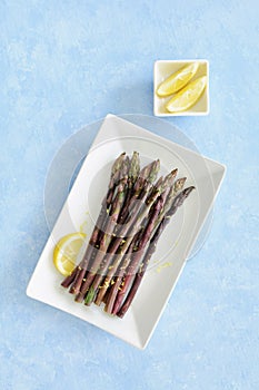 Purple organic asparagus with lemon