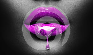 Purple Paint dripping, lipgloss drops on sexy lips, bright liquid paint on beautiful model girl`s mouth, black skin. Lipstick