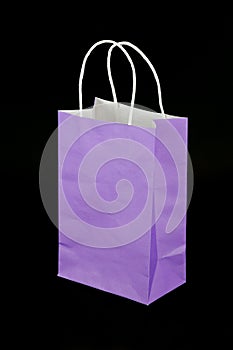 Purple paper gift bag isolated on black background