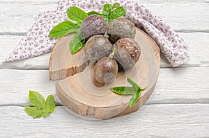 Purple passion fruit with leaves on wooden board