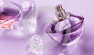 Purple perfume bottle on glossy background, sweet floral scent, glamour fragrance and eau de parfum as holiday gift and luxury