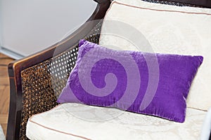 Purple pillow on wooden chair