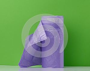Purple plastic trash bags with strings on white background, close up