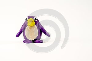 purple Play dough plasticine penguin with yellow bill isolated on a white background with copy space